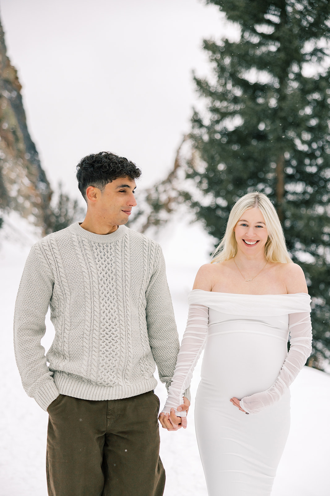 mom and dad to be walking hand in hand through the snow